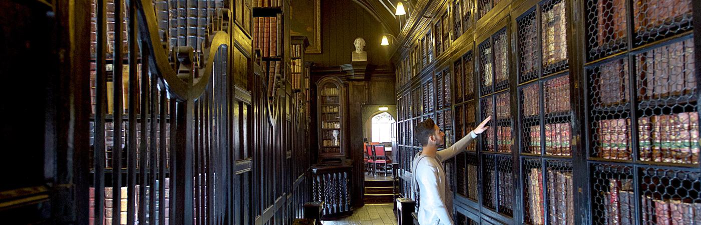 Student looking through the shelves of an old library